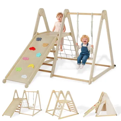Two toddlers playing on a wooden indoor playground set with a slide, swing, and climbing net.