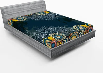 A fitted sheet with a colorful paisley and mandala pattern is displayed on a bed frame.