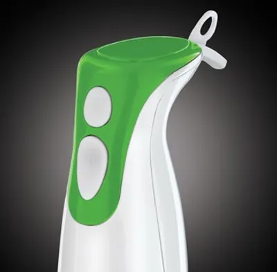 Close-up of the top part of a green and white immersion blender.
