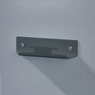 A dark gray metal wall bracket is mounted on a light gray wall.