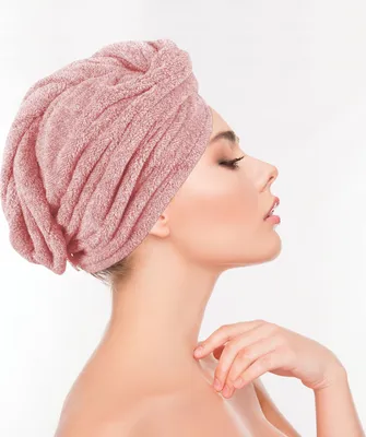 A woman wearing a pink hair towel turban.