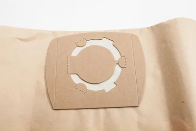 A close-up of a vacuum cleaner bag with a circular connector.