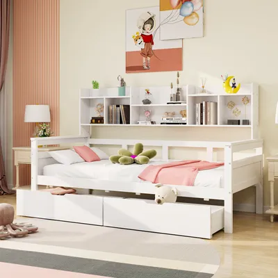 A white wooden daybed with drawers and a bookshelf headboard, decorated with pillows and a blanket.