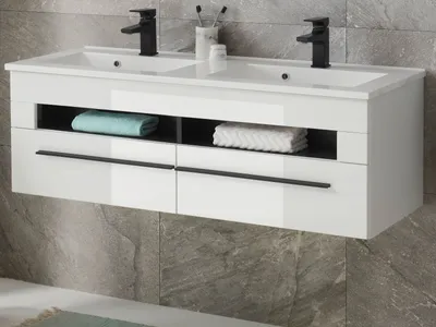 A white double vanity sink with black faucets mounted on a gray tiled wall.