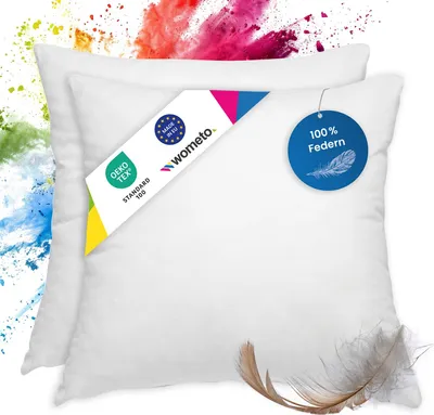 Two white pillows with marketing tags and a feather.