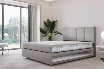 A cutaway view of a mattress on a bed frame in a bedroom.