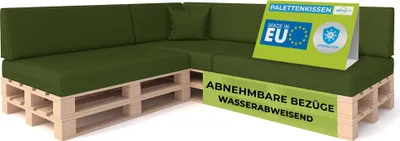 A green modular sofa made of cushions on wooden pallets, with marketing signs.