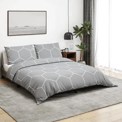 A bedroom scene with a bed, nightstand, plant, and artwork.