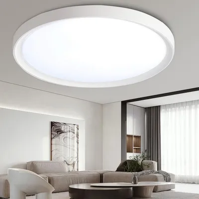 A modern living room with a large, round LED ceiling light.