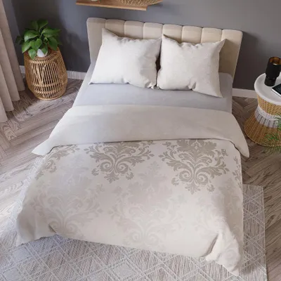 A neatly made bed with a beige damask duvet cover and two pillows.