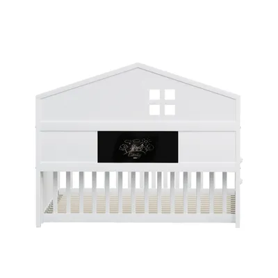 A white crib with a house-shaped headboard and a chalkboard panel.