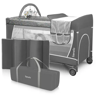A baby travel cot with accessories laid out.