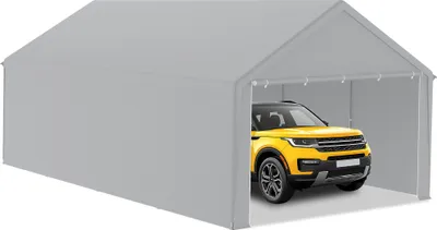 A yellow SUV is parked inside a large, gray tent garage.