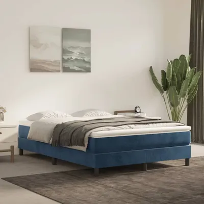 A bedroom scene with a bed and artwork on the wall.