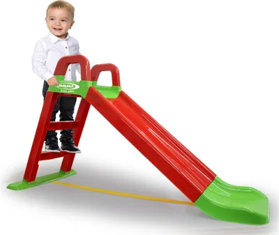 A child stands on the steps of a red and green slide.