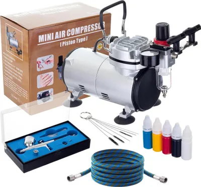A mini air compressor kit with accessories, including an airbrush, hose, cleaning tools, and paint bottles, displayed with its packaging box.