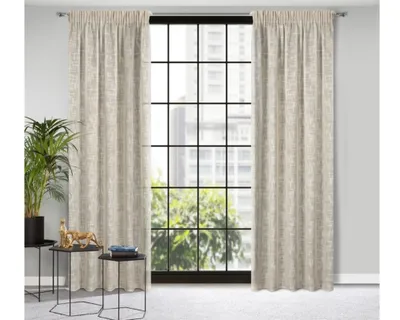 A pair of beige curtains hanging in front of a large window with a city view.