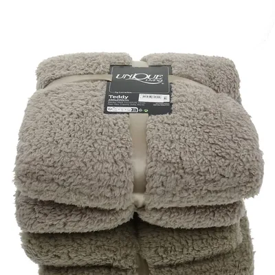 A folded teddy blanket with a product tag.