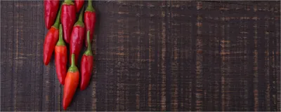 Produktbild von Wallario Poster - Rote Paprikaschoten auf einem dunkelbraunem Holzbrett, Kunstdruck Größe: 80 x 200 cm