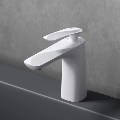 A white faucet is shown on a gray countertop against a gray textured wall.