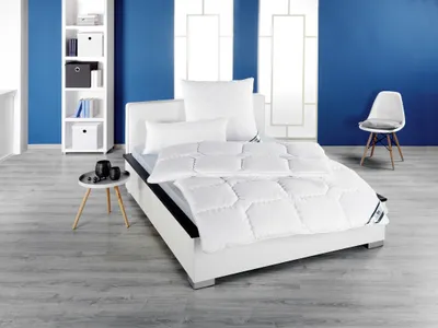 A bedroom scene with a bed, bookshelf, and chair.