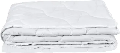 A white quilted comforter folded and stacked.