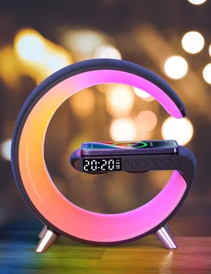 A modern, circular lamp with a built-in clock and wireless charging pad, displaying a phone.