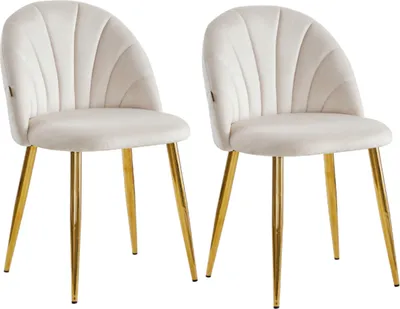 Two beige upholstered dining chairs with gold metal legs are shown against a white background.