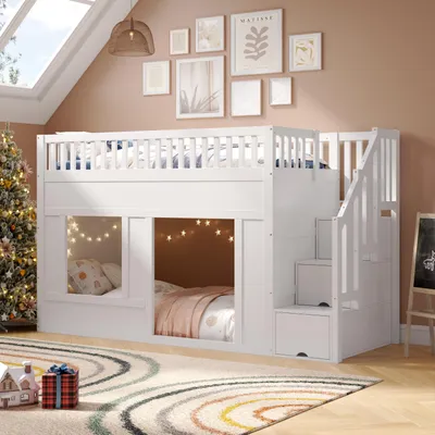 A white bunk bed with stairs is set up in a room with a Christmas tree and artwork on the wall.