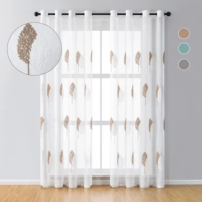 A pair of sheer curtains with a leaf embroidery pattern hanging in front of a window.