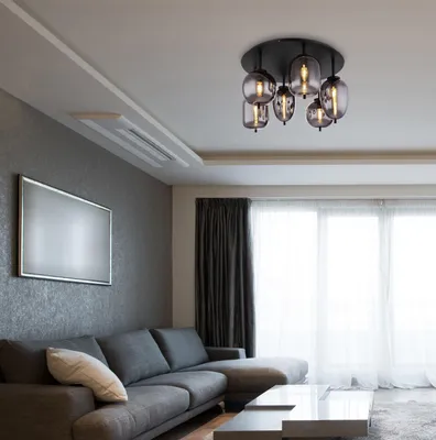 A modern living room with a sectional sofa, coffee table, and a ceiling light fixture.