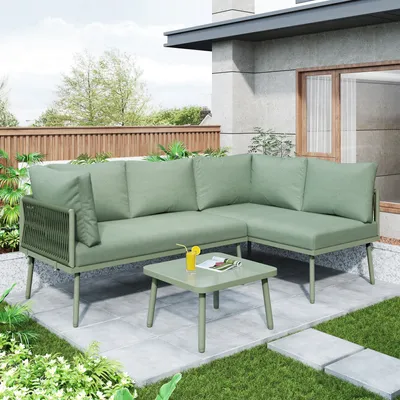 An outdoor patio setting with a green sectional sofa and coffee table.