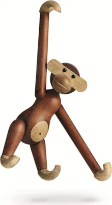 A wooden monkey toy is hanging against a white background.