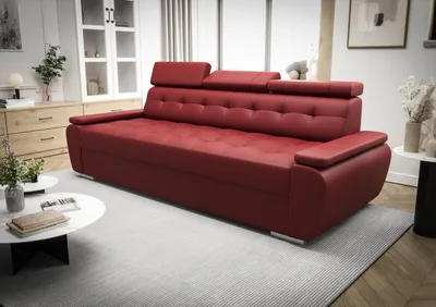 A red leather sofa is shown in a living room setting with a white rug and a wooden dresser in the background.