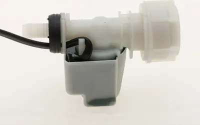 A close-up of a water inlet valve with an electrical component.