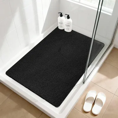 Obrázok produktu pre Protisklzová podložka pod sprchu, 60x90 cm, čierna, vyrobená z PVC s textúrou podobnou ľufy, s odvodňovacími otvormi