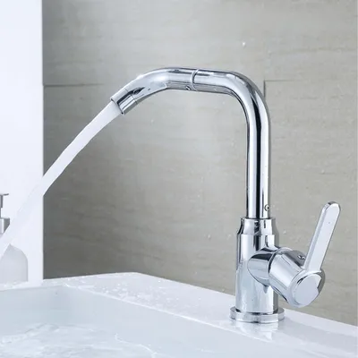 A chrome faucet with water flowing into a white sink.
