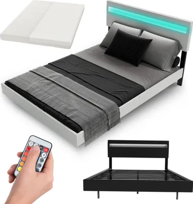 A white bed frame with a mattress, bedding, and a remote control for LED lights.