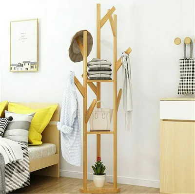 A wooden coat rack with shelves and hooks in a room next to a bed.