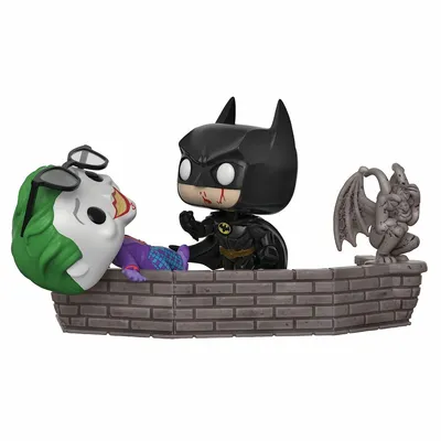 Batman and Joker Funko Pop! figures on a brick wall with a gargoyle.