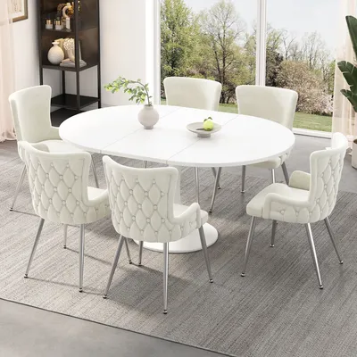 A dining set with an oval table and chairs in a well-lit room with a large window overlooking a garden.