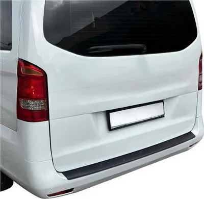 The rear of a white van with a black bumper protector installed.