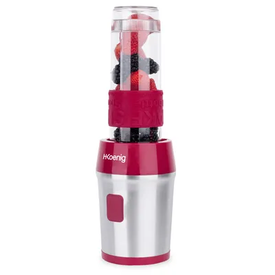 A portable blender filled with berries sits on a white background.