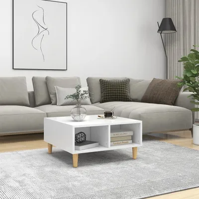A modern living room scene with a white coffee table in the foreground, a sectional sofa in the background, and a piece of abstract art on the wall.