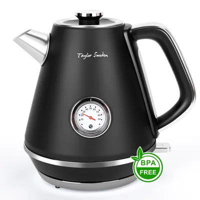 A black electric kettle with a retro design, featuring a built-in thermometer and a silver spout and handle accents, is displayed against a white background. A green circular badge indicating "BPA FREE" is visible on the lower right side.