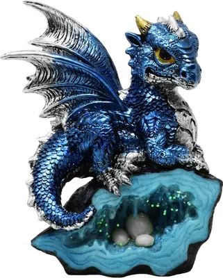 A blue dragon figurine sits on a crystal-like base with glowing green accents and pebbles.