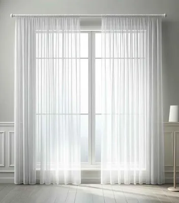 A pair of white sheer curtains hanging in front of a large window.