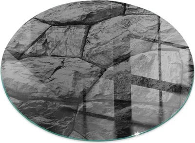 A circular glass floor plate with a stone pattern, reflecting light.