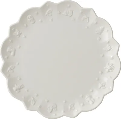 A white plate with embossed festive designs on the rim, shown from a top-down perspective.
