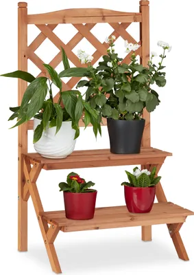 A wooden plant stand with a trellis back, displaying several potted plants on its shelves.